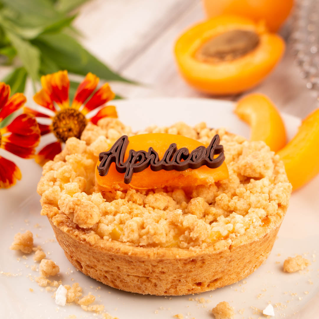 Aprikosentörtchen mit Crumble Als topping Schriftzug aus 3D Choco Dark  gedruckt mit Procusini 3D Lebensmitteldrucker